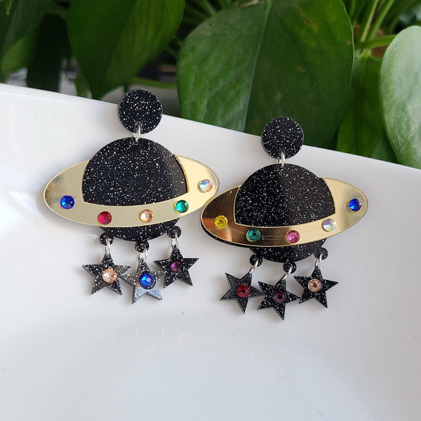 These Cosmic Tassel Acrylic Saturn Earrings are the perfect accessory to elevate any outfit. They are made from high-quality acrylic, making them lightweight and comfortable to wear. With playful tassel details and a bold, eye-catching design, these earrings are sure to turn heads.